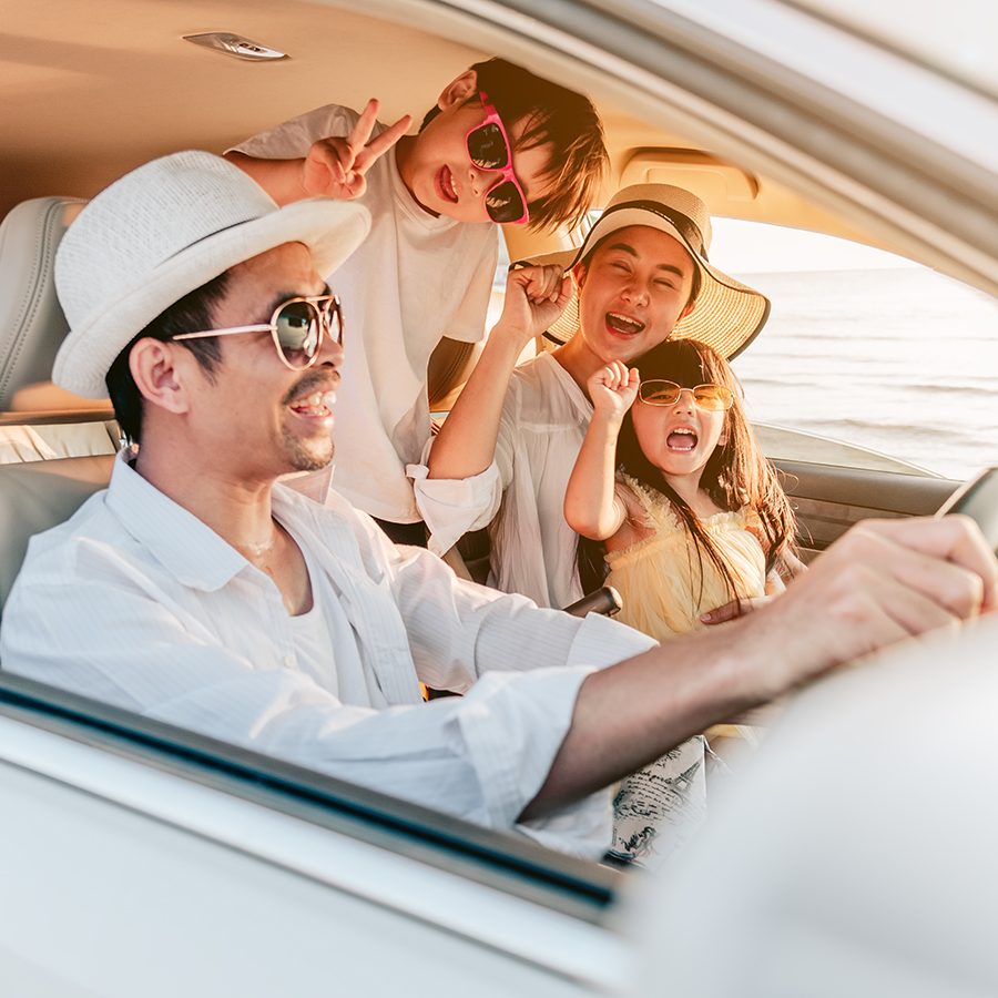 A family enjoying beach trip with their favorite car