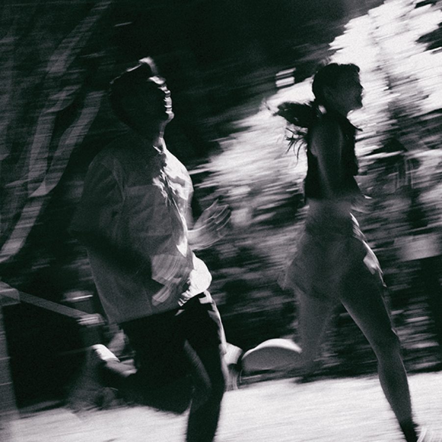 A man and woman running in the dark in Hong Kong