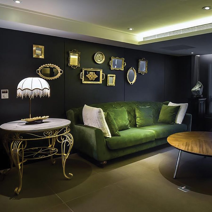 The interior of the modern hotel lounge decorated with green sofa and frames of artwork on the wall inside Just Sleep Kaohsiung Station, Taiwan