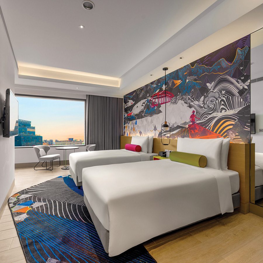 Interior of two double bedroom with city view and artwork on the wall at Hotel Indigo Taipei North, Taiwan