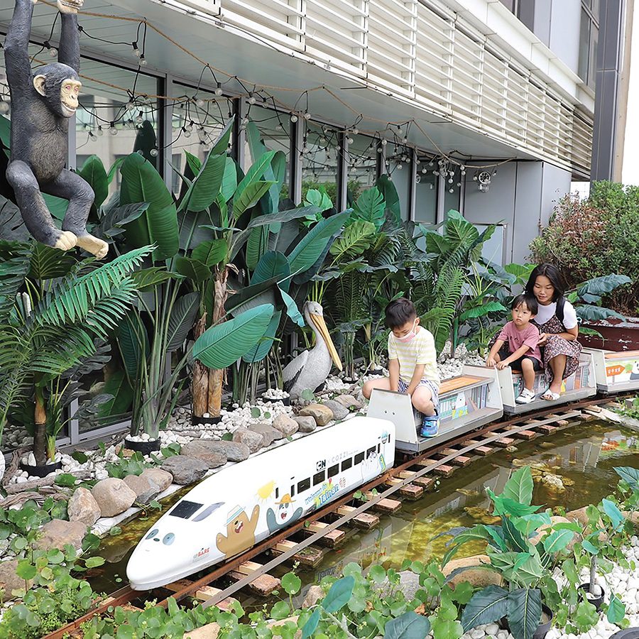 A mother playing with her child on a train in Hotel Cozzi Ximen, Tainan, Taiwan