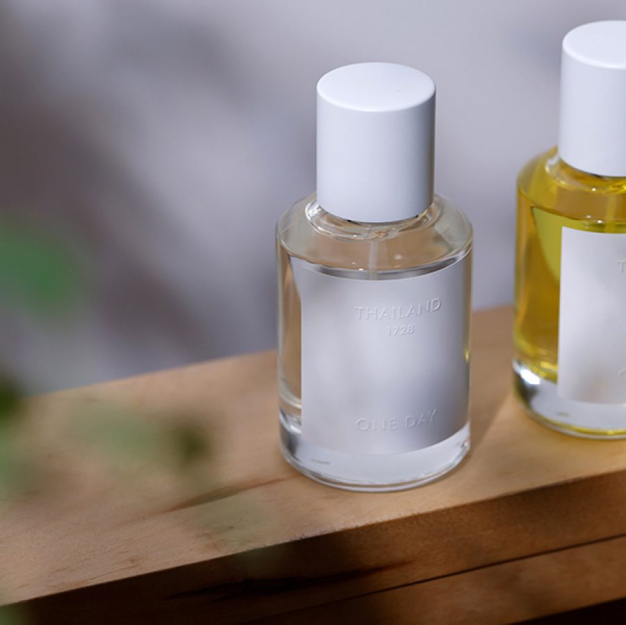 Two bottles of Thailand One Day fragrance on display on wooden plank