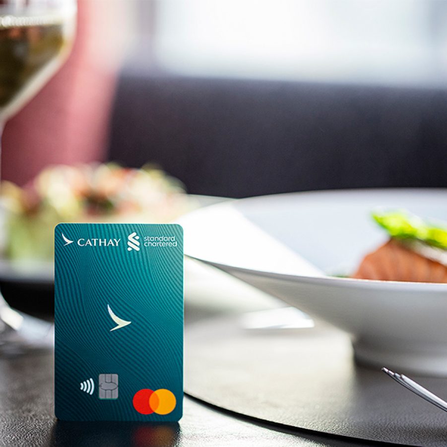 A Standard Chartered Cathay Mastercard credit card on a restaurant table