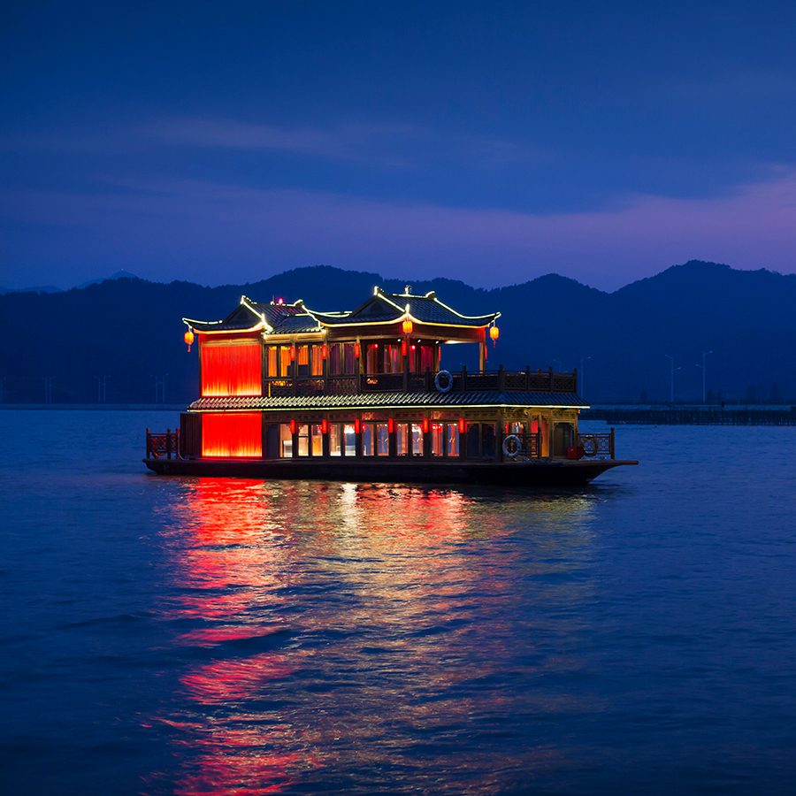 Photo of a boat traveling on the lake at night
