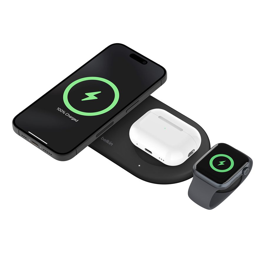 Headphones, phone and Apple watch charging on a Belkin magnetic wireless charging pad 