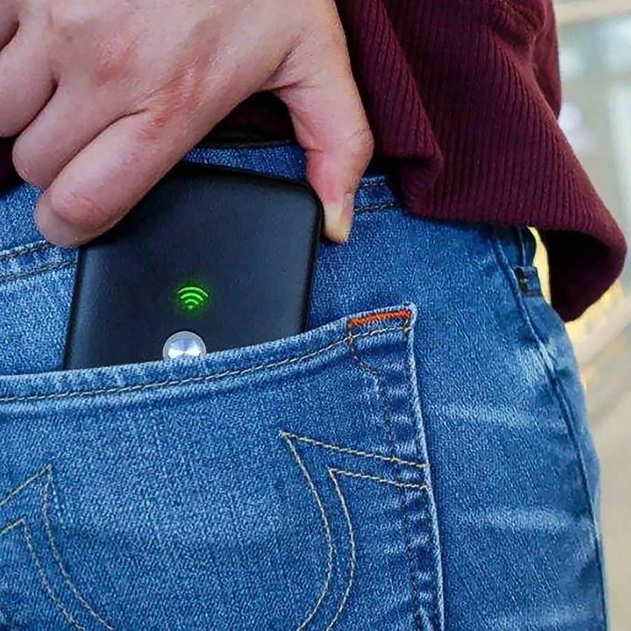 Person sliding a SmartGo portable Wi-F i hotspot into their back pocket