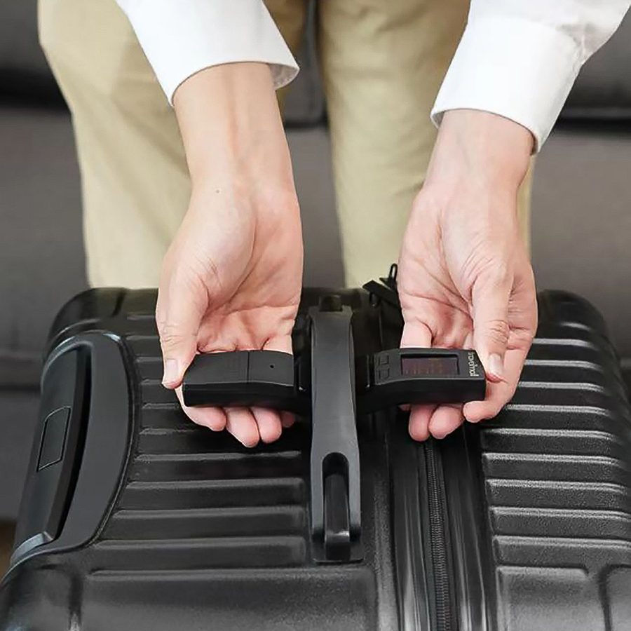 Person demonstrating how the Travelmall Switzerland portable luggage scale works