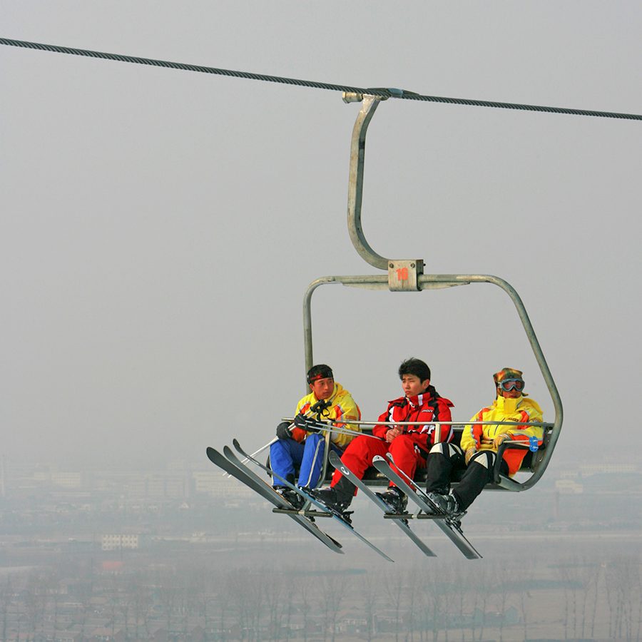 Three skiers on a chairlift at Nanshan Ski Resort in Beijing