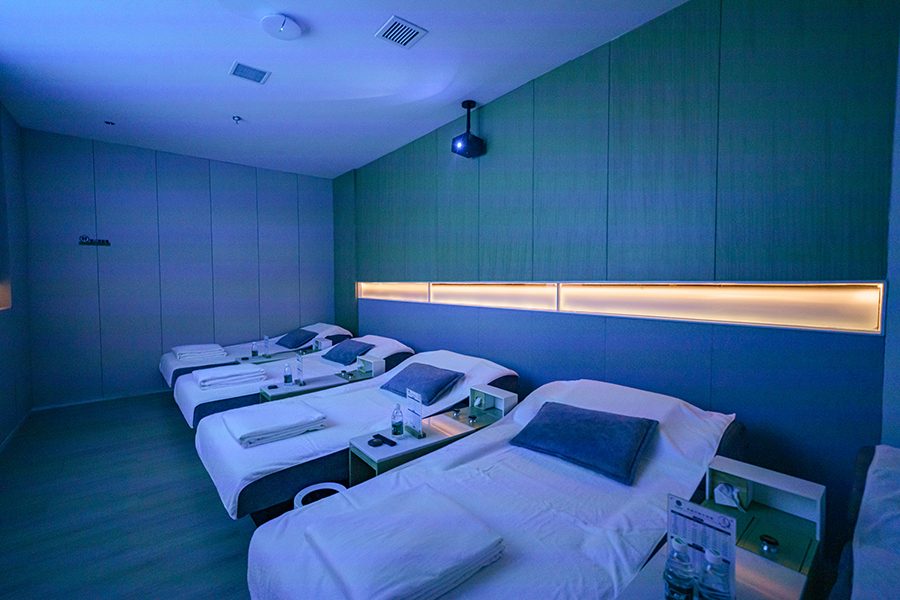 Four beds with pillows and blankets in a room in Heat Joy Spa