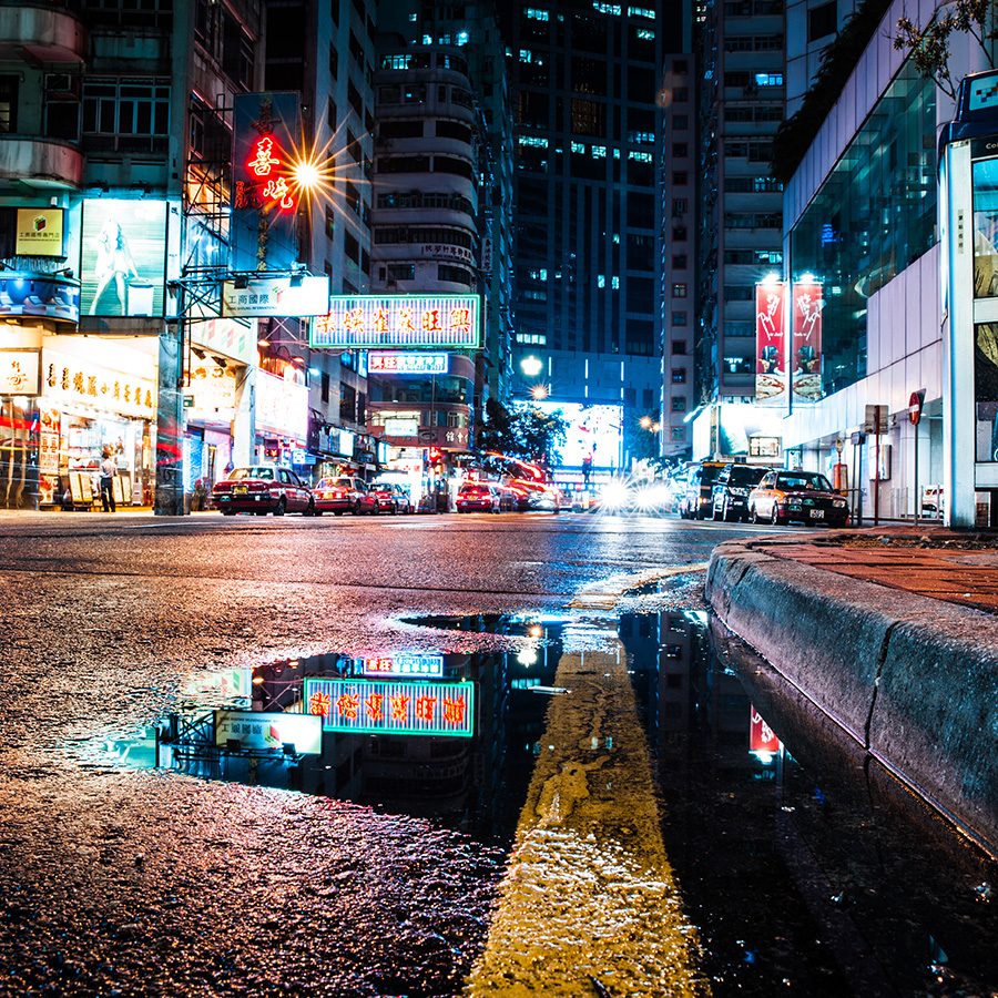 A road in Wan Chai, Hong Kong, illuminated by streetlights at night.  