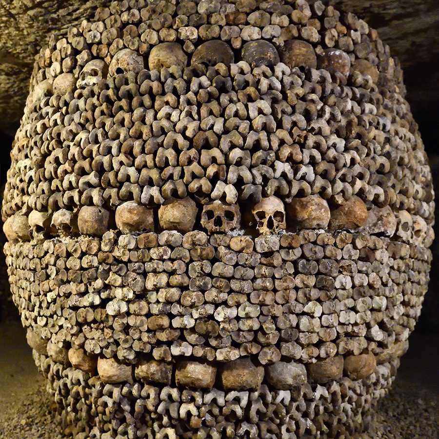 A circular shaped column made entirely from skulls in the Paris Catacombs. 