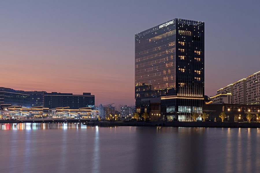 An exterior view of Hyatt Centric Lakeside Ningbo across Tonxin Lake at night in China 
