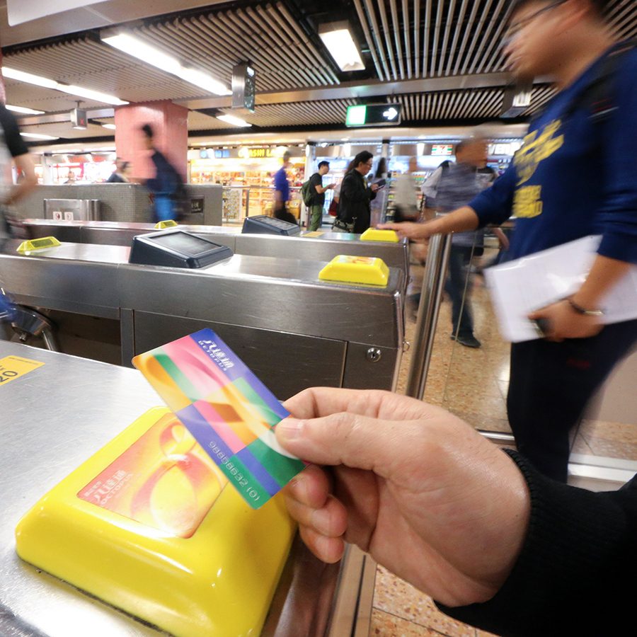 A metro passenger tapping their Octopus card in an MTR station.