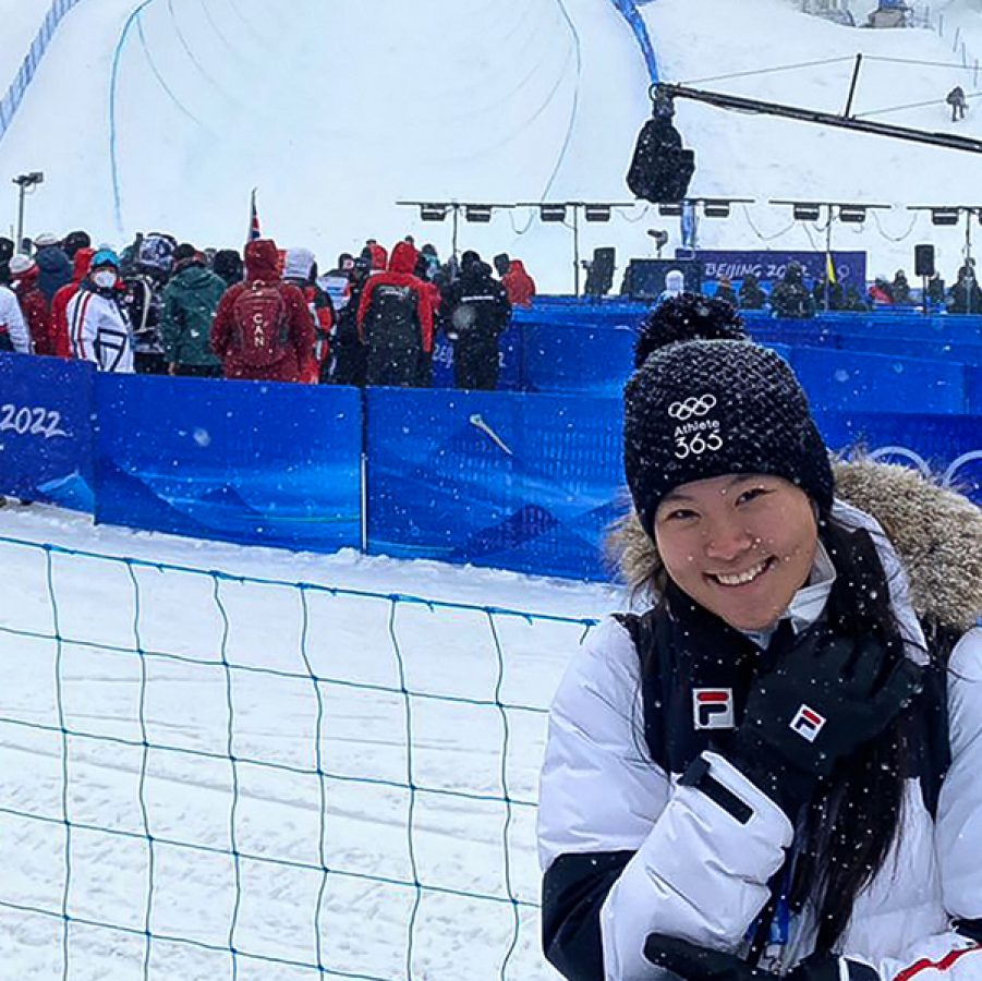 Audrey King smiling in front of the ski slopes at the 2022 Winter Olympics