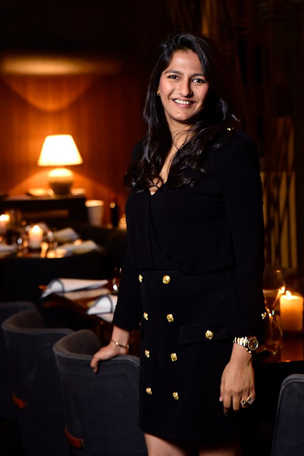 Aditi Dugar of Masque and Urban Gourmet India standing in a dark room