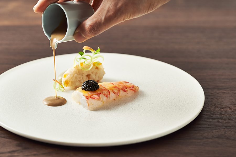 Sauce being poured on a dish at Mingles in Seoul