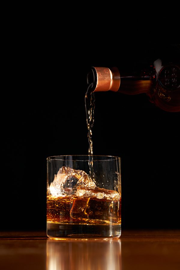 Person pouring themselves a whisky 