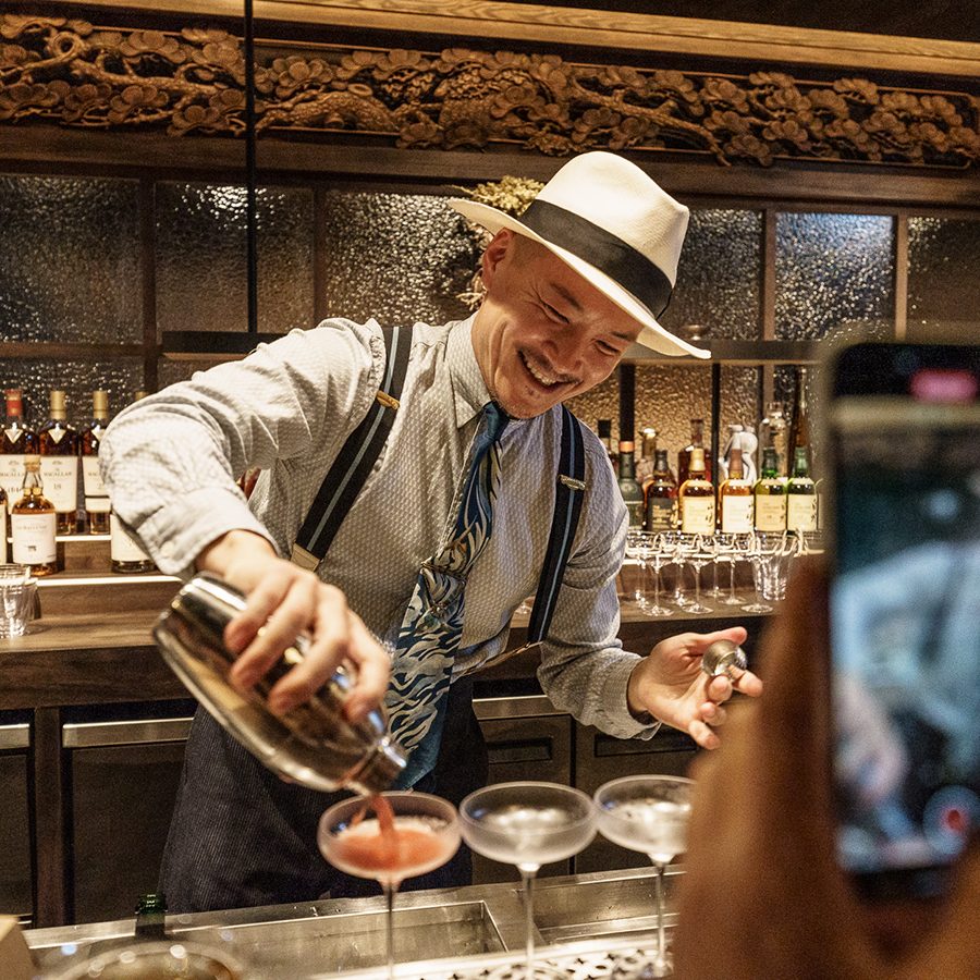 Shingo Gokan laughing and pouring drinks at Gokan in Hong Kong