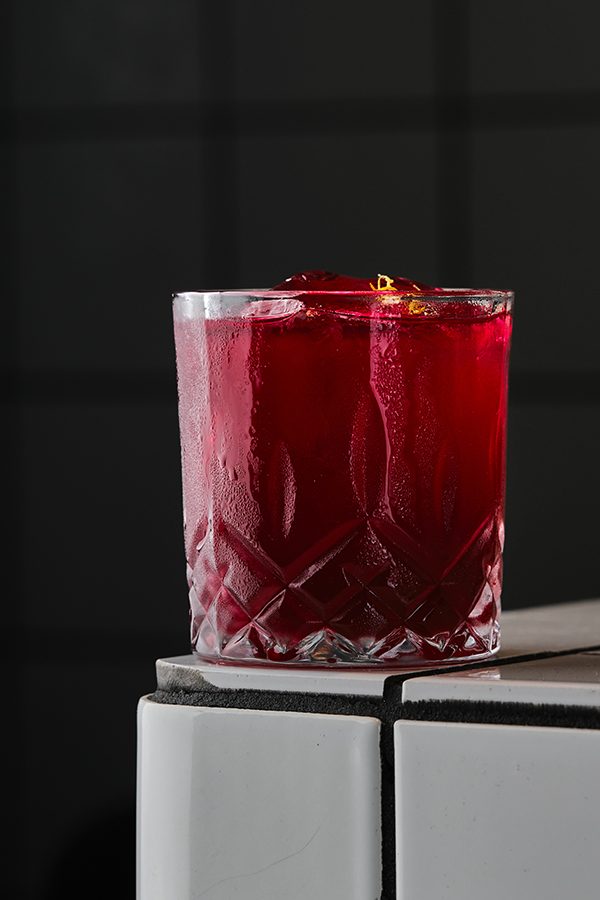 A dark red drink on the corner of a table at Mostly Harmless
