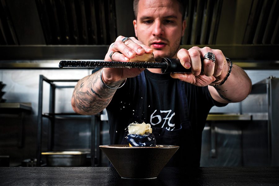 Kray Treadwell of 670 Grams, Birmingham, grating cheese over a dish