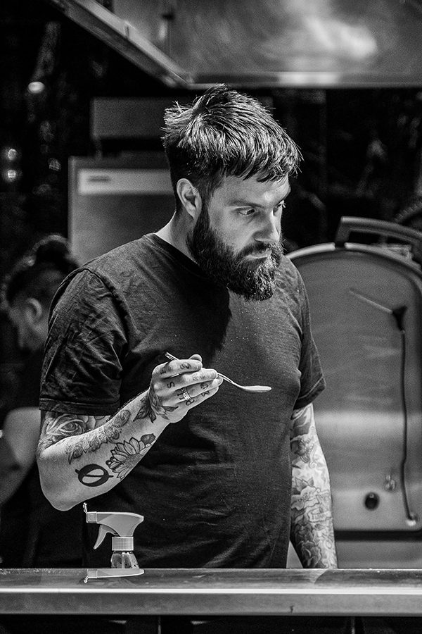 Alex Claridge holding a spoon in the kitchen