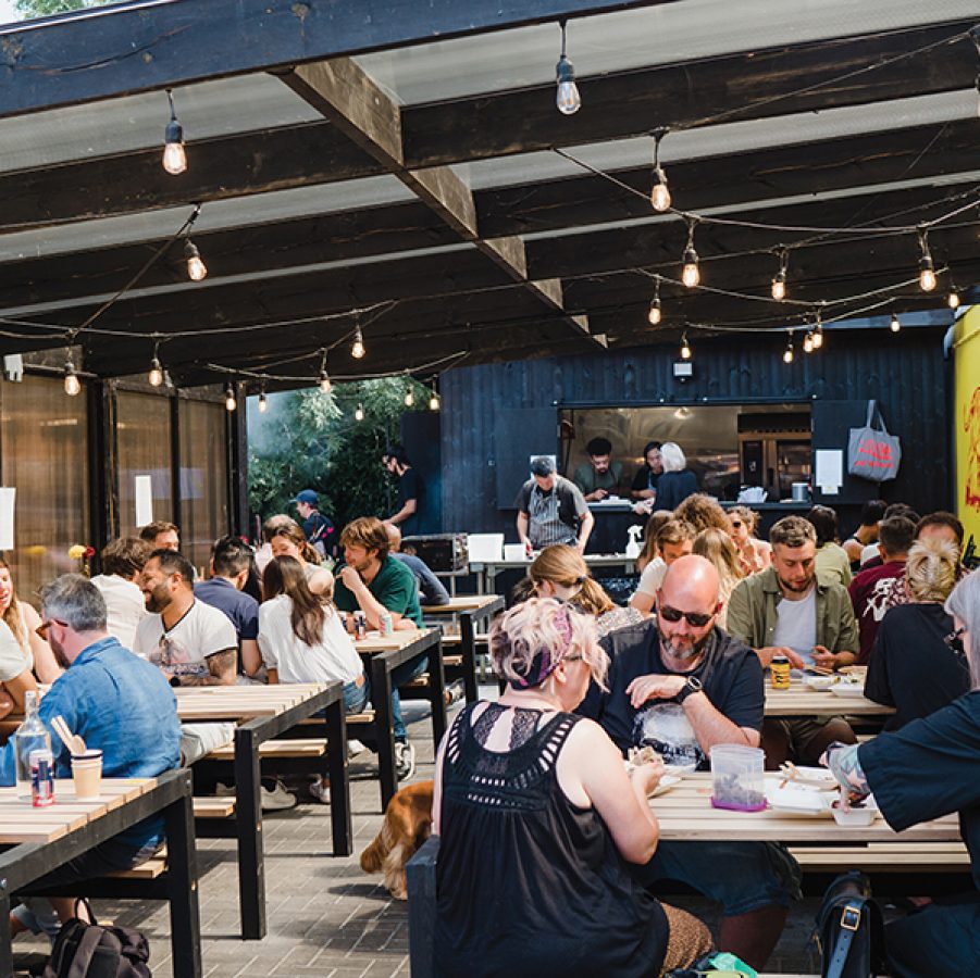 Groups of people eating at tables on the terrace of Eat Vietnam, Birmingham 