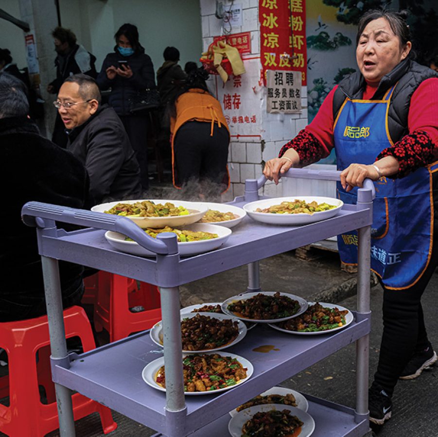 Server pushing a cart full of Sichuan dishes in Dongzikou Chenshi Liangfen, Chengdu