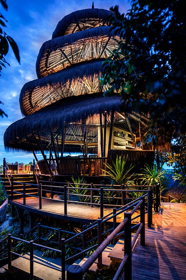 The tiered bamboo structure of Dodo Bar at Cempedak Private Island, Indonesia, seen at twilight