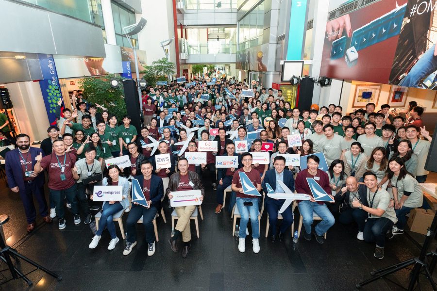 A group of seated people holding signs at the Cathay Hackathon