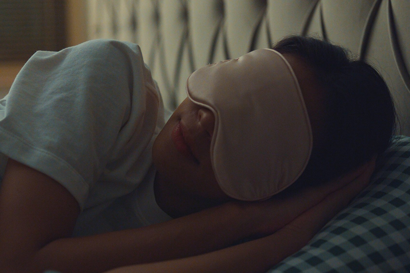 Close-up of a woman sleeping with an eye mask on. 