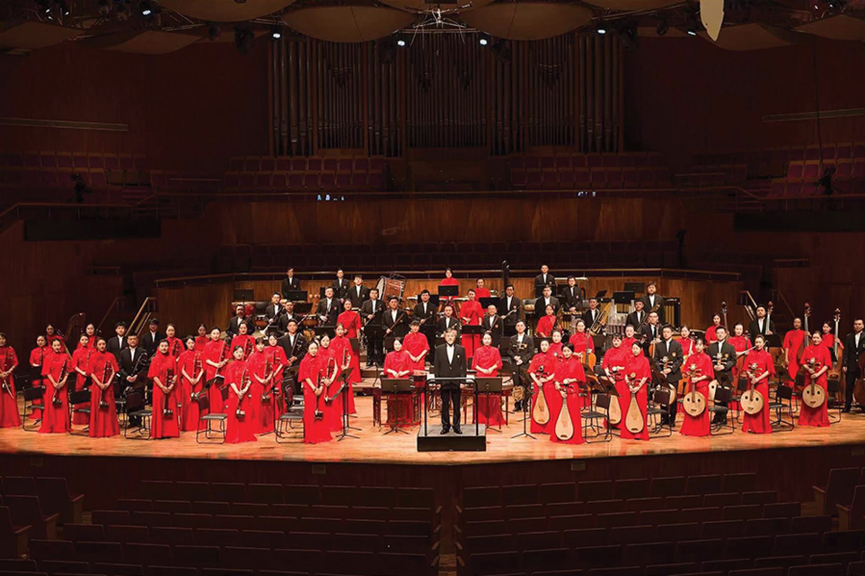 The Guangdong Chinese Orchestra standing on stage with their instruments