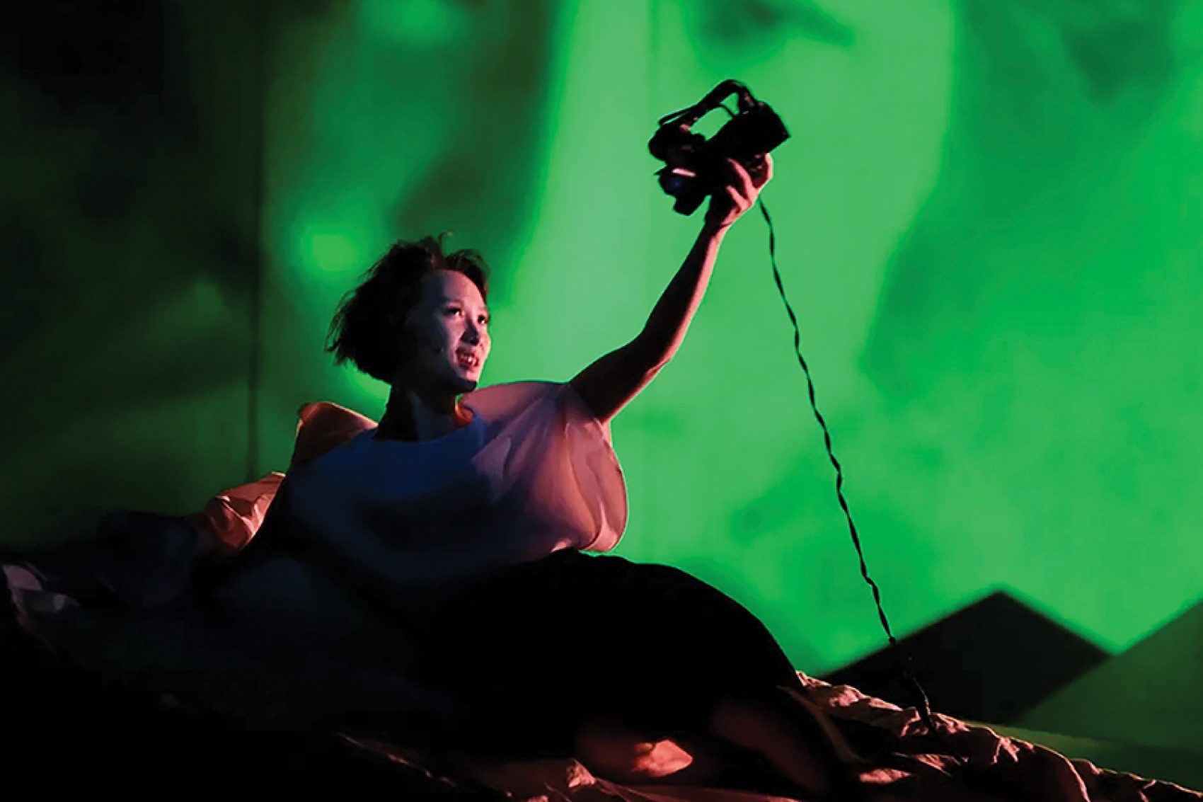 An actress holding a camera on stage for Letter from an Unknown Woman