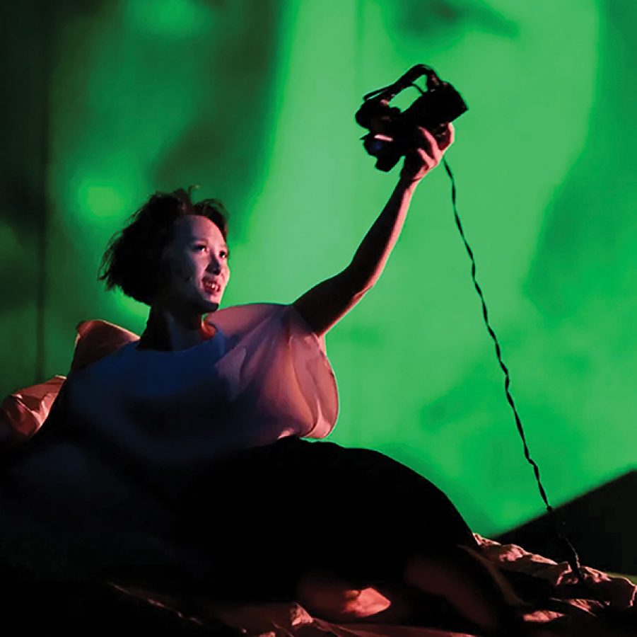 An actress holding a camera on stage for Letter from an Unknown Woman