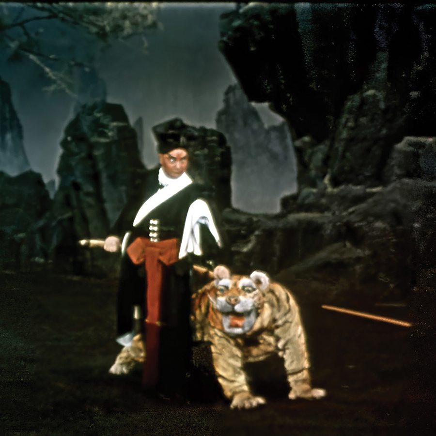 A film still of Wu Song, showing a man in traditional Chinese attire killing a tiger