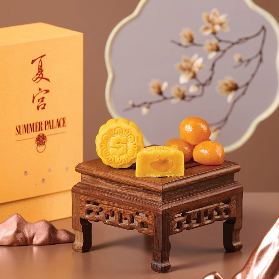 Island Shangri-La’s mooncakes placed on a small brown table with a yellow box next to it