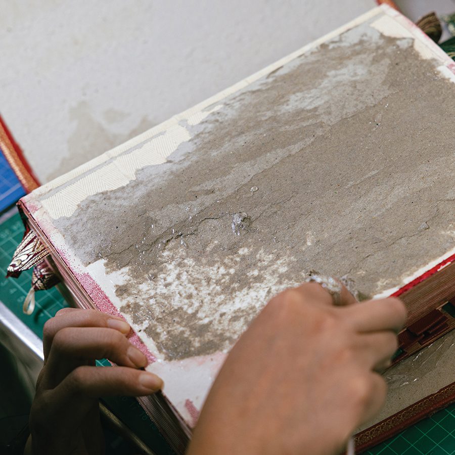 A close up of Percy So restoring a book during repair 