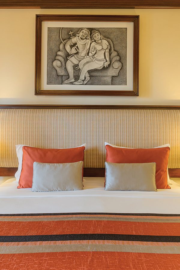 A bed with a picture hanging above it in a guestroom at Amaya Hills hotel in Kandy, Sri Lanka