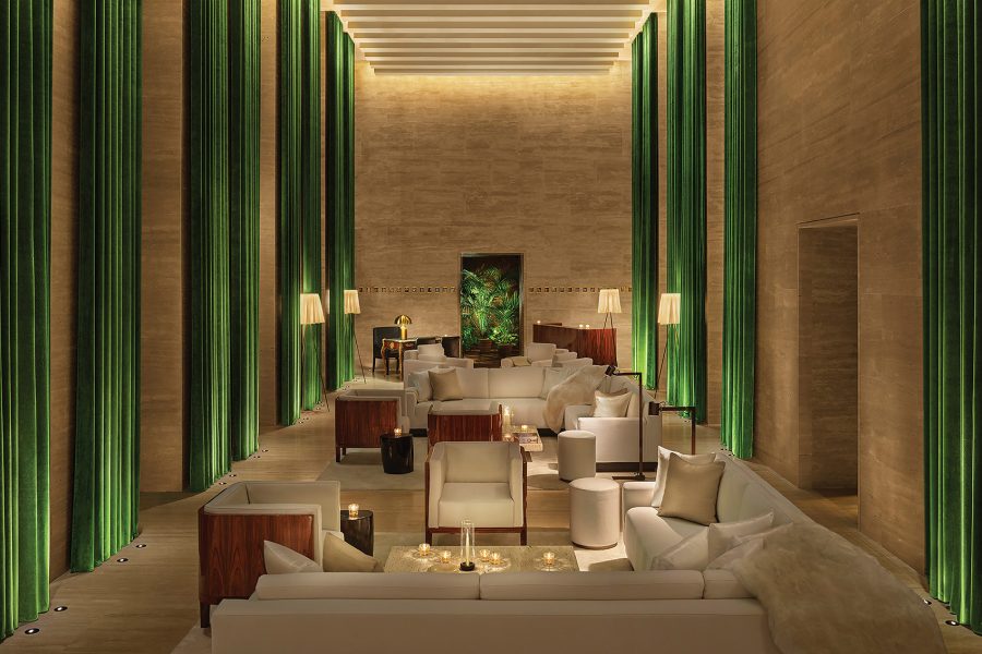 A long shot of a neutral-coloured lobby with green drapery, at The Rome Edition hotel