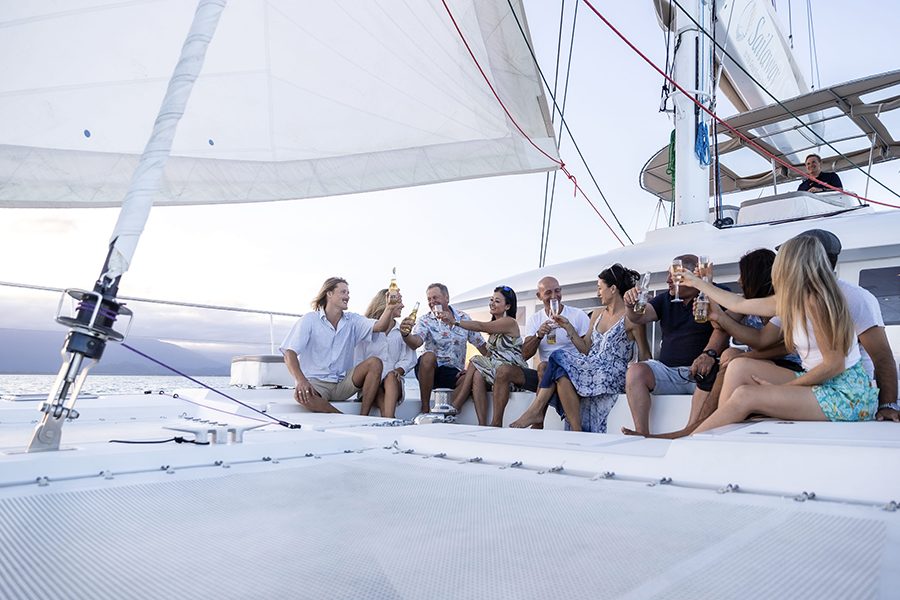  group sitting together on a large sail boat having fun during daytime 