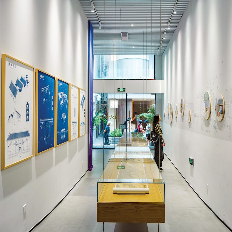 An interior view of the Nantou 1820 Digital Exhibition Hall and a woman looking at art on the wall