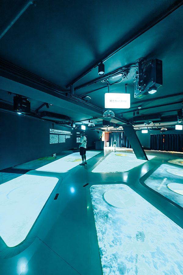 A man standing in a bright exhibition space full of LED screens on the floor