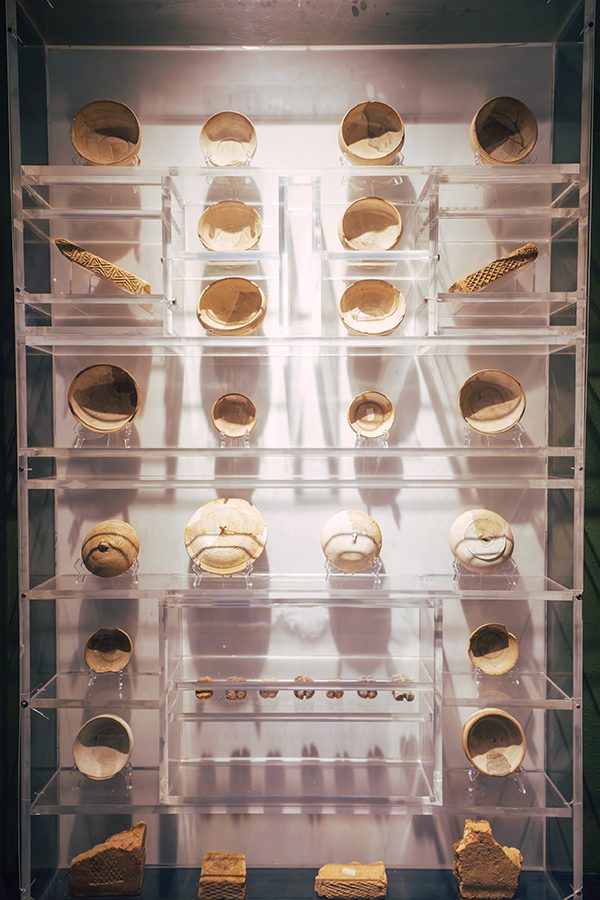 A close-up of ancient artefacts on display behind a clear cabinet at Nantou Ancient City Museum in Shenzhen, China