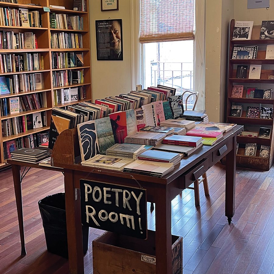 An interior view of City Lights bookstore in North Beach with books on shelves and on wooden tables