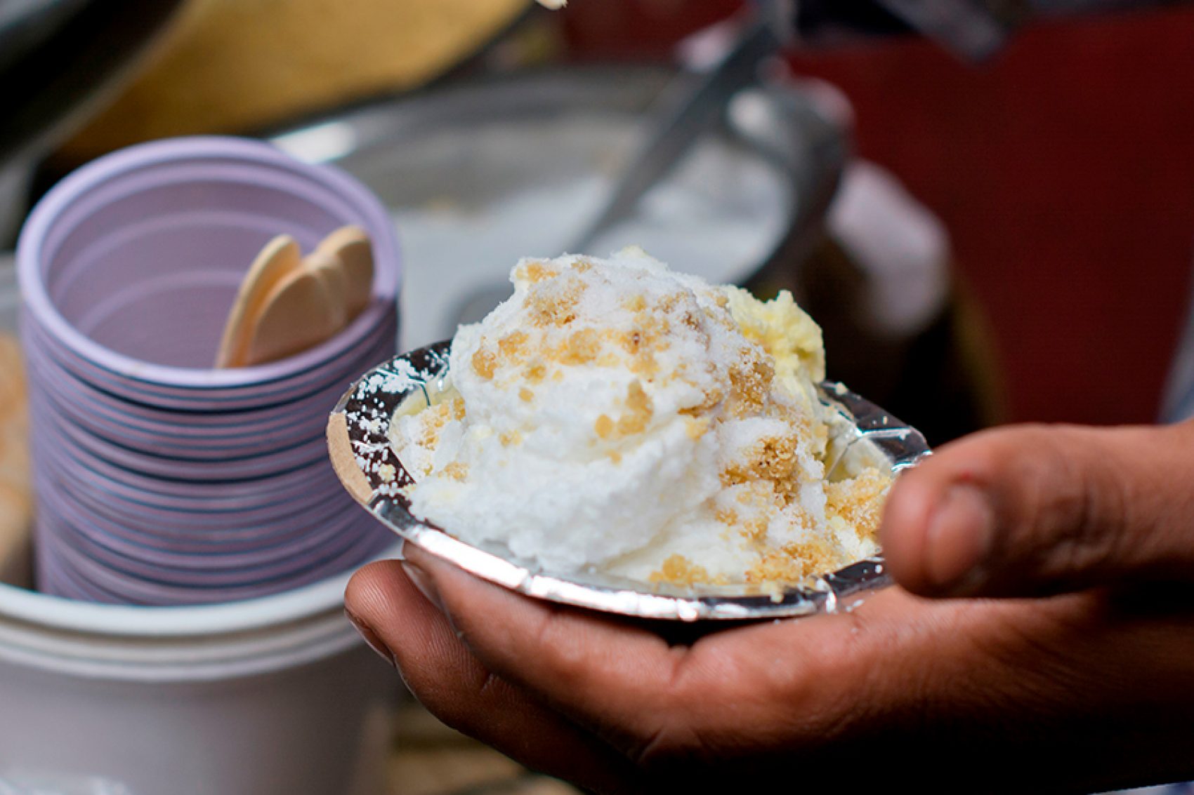 A closeup of a fluffy daulat ki chaat garnished with sugar, milk, saffron and nuts