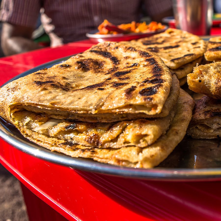 A close-up of Indian paratha on a large silver platter 