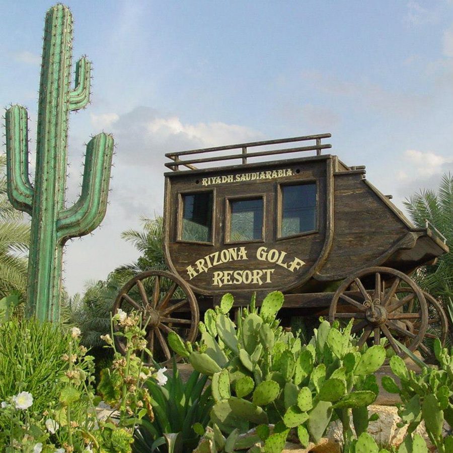 A wooden carriage with ‘Arizona Golf Resort’ text and some cacti in front 