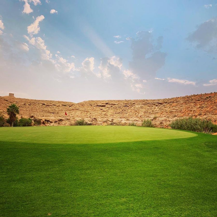 Dirab Golf and Country Club with blue skies and a hill in the background