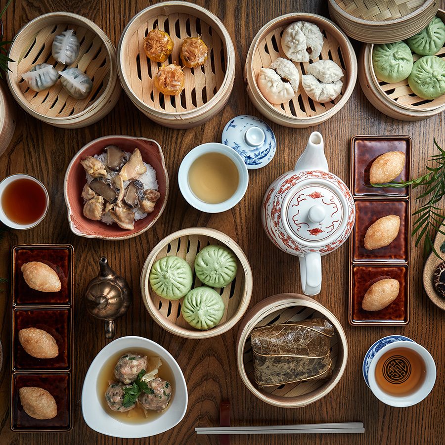 A flat lay with baskets of dim sum and a pot of tea on a table at Duddell’s, Hong Kong.  