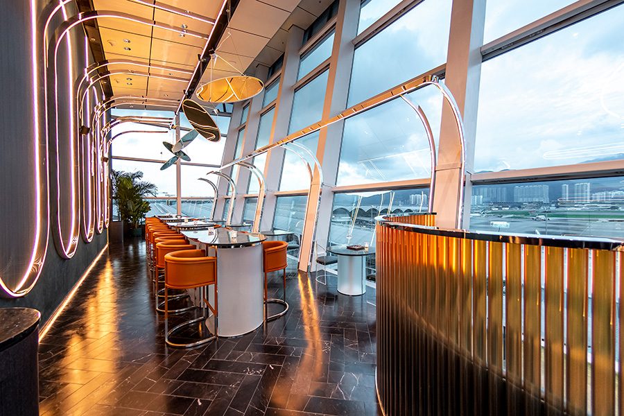 A high table with orange high chairs at Intervals Sky Bar & Restaurant, Hong Kong International Airport. 