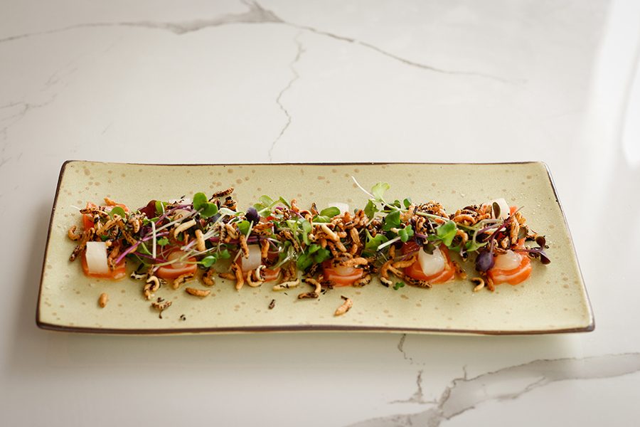 A rectangular plate of food on a marble surface. 